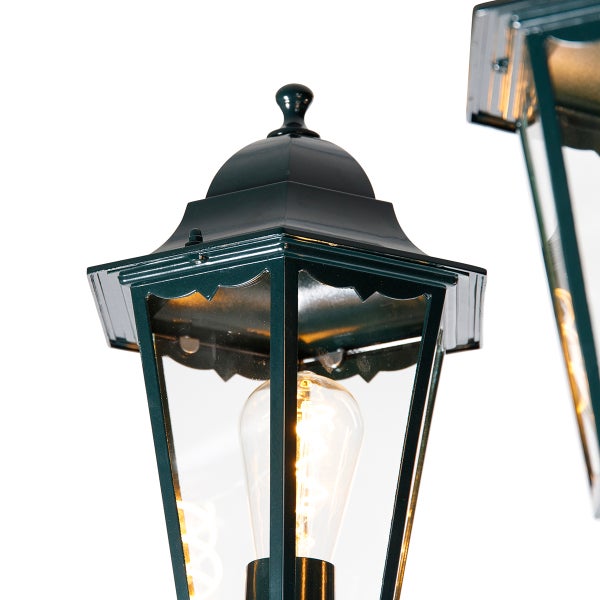 Klassische Außenleuchte mit dunklem Metallgehäuse, Klarglas und leuchtendem Filament-Leuchtmittel.