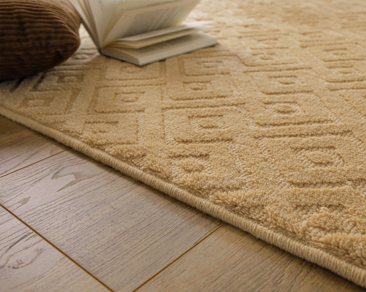 Strukturierter Teppich mit geometrischem Muster auf einem Holzboden.