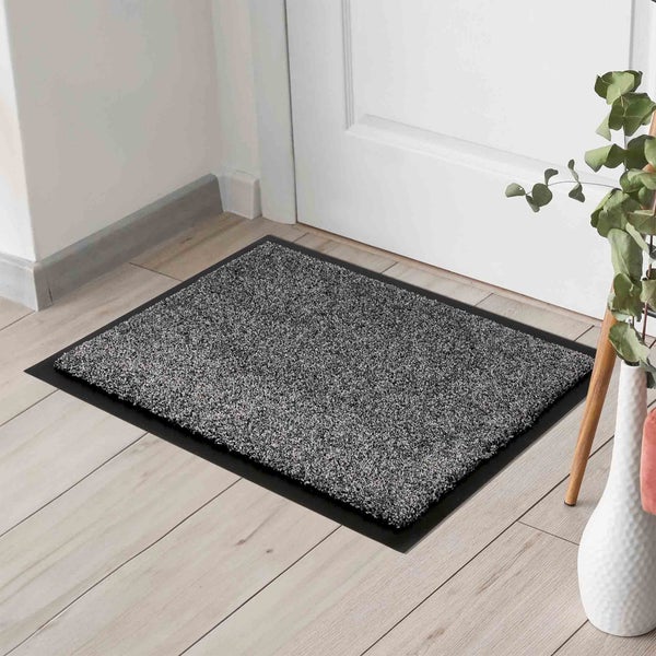 Schmutzfangmatte vor einer Tür auf einem Holzboden