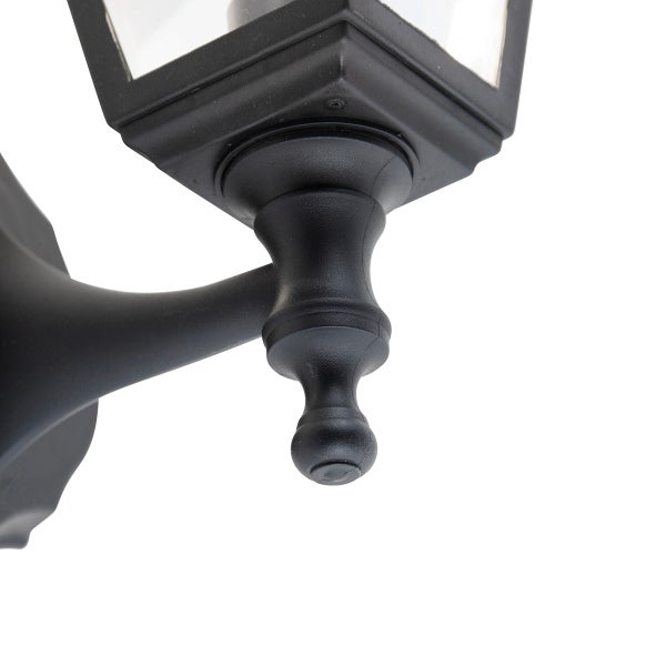 Nahaufnahme der dekorativen Halterung einer schwarzen Außenwandleuchte im klassischen Laternen-Stil.