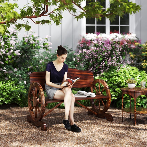Eine Frau sitzt auf einer Gartenbank mit Rad-Design und liest ein Buch.