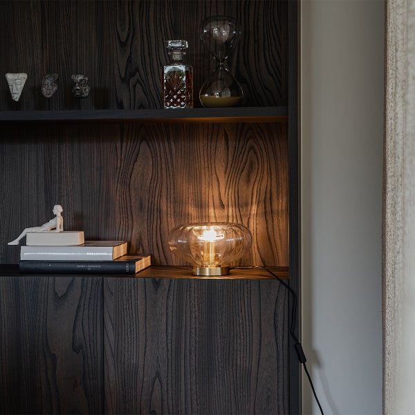 Dekoratives Regal mit einer Tischlampe, Kunstobjekten und Büchern