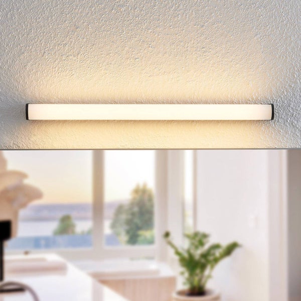 Moderne lineare LED-Badezimmerleuchte an einer Wand montiert, die ein warmes Licht nach oben und unten abgibt.