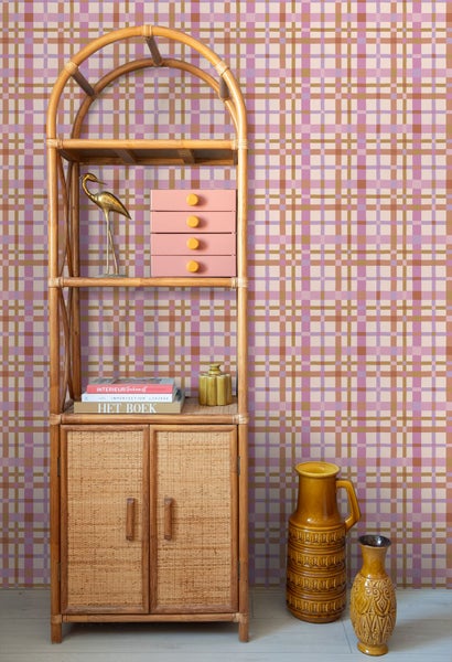 Karierte Tapete in einem hellen Zimmer mit einem Rattanregal, Dekorationsartikeln und Keramikvasen im organisierten Retro-Stil.