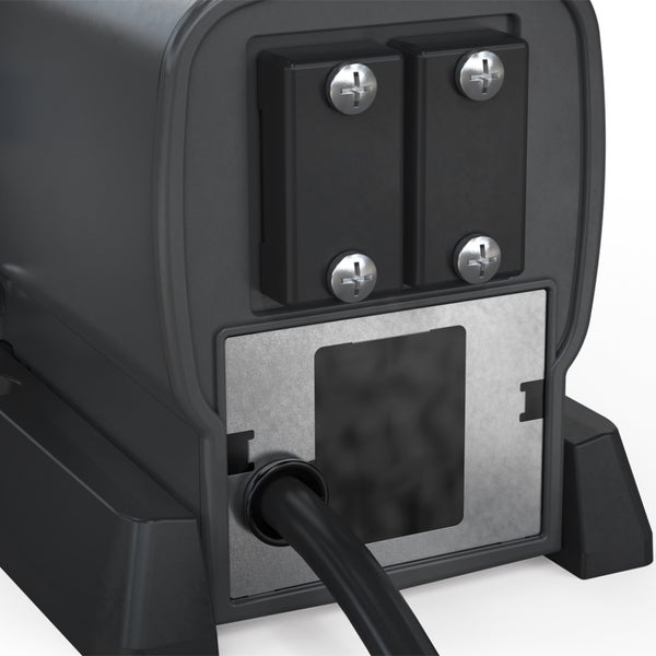 Detailansicht der Gehäuserückseite eines technischen Geräts mit verschraubten Abdeckungen, Metallplatte und Kabeldurchführung.