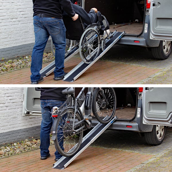 Zusammensetzung eines Mannes, der eine Person im Rollstuhl und ein Fahrrad über eine Rampe in einen Transporter schiebt.