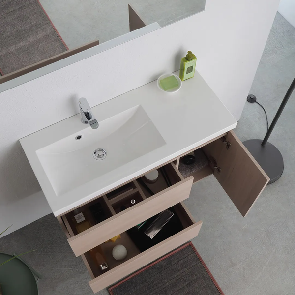 Waschtischunterschrank in Holzoptik mit weißem Waschbecken, Armatur, zwei geöffneten Schubladen und einer Tür.