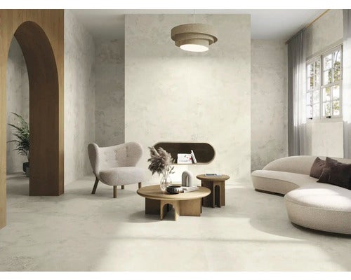 Wohnzimmer mit Bodenfliesen, Sessel, Sofa, Tisch und Lampe für ein modernes Wohnambiente.