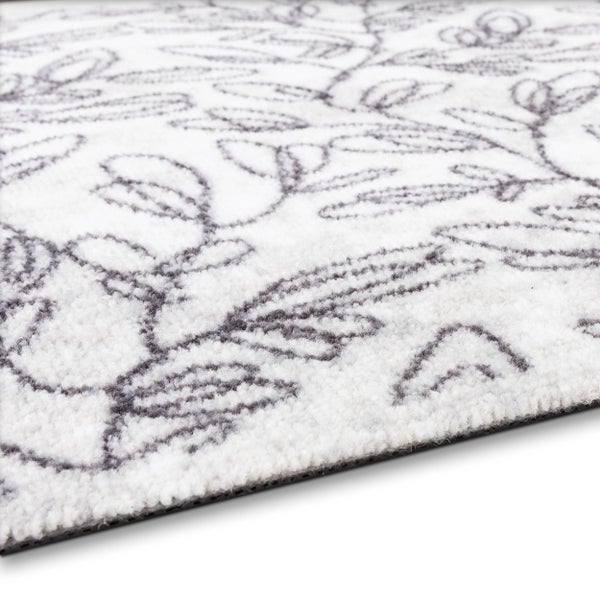 Teppich mit floralem Blattmuster, weicher Flor, Nahaufnahme von Textur und Kante.