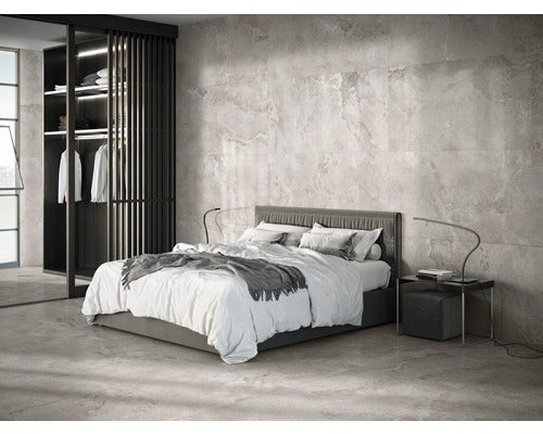 Schlafzimmer mit Bett, Nachttisch und Fliesenwand