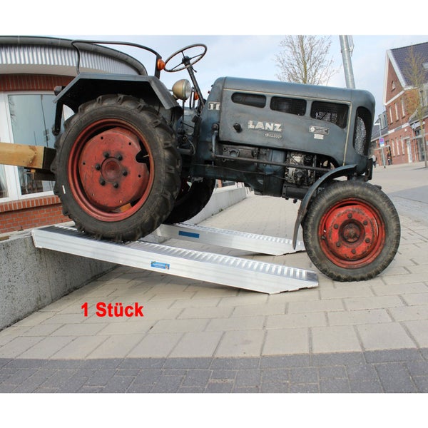 Traktor fährt über zwei Aluminium-Auffahrrampen