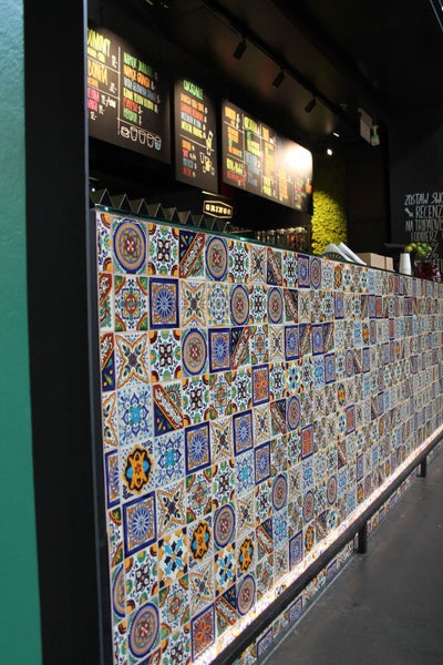 Theke mit bunten Fliesen und Speisekarte im Hintergrund.