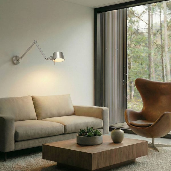 Wohnzimmer mit Sofa, Sessel, Couchtisch und Wandleuchte