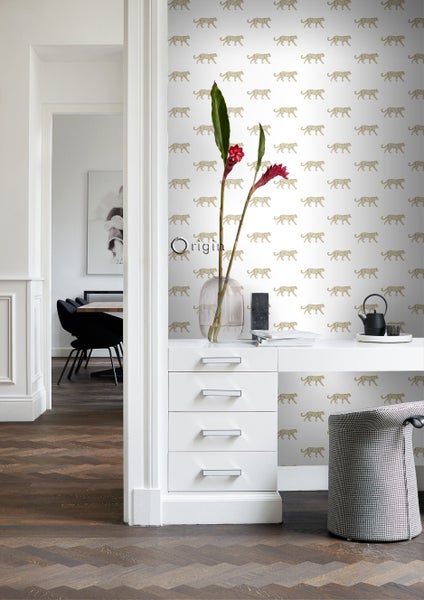 Innenraum mit Tapete mit Leopardmuster, Schreibtisch und Stuhl.