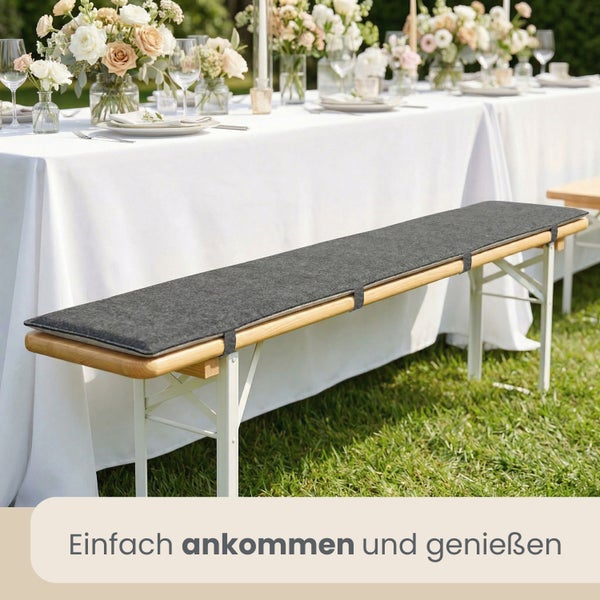 Dunkles Sitzpolster auf einer Bierbank bei einer gedeckten Festtafel im Garten.