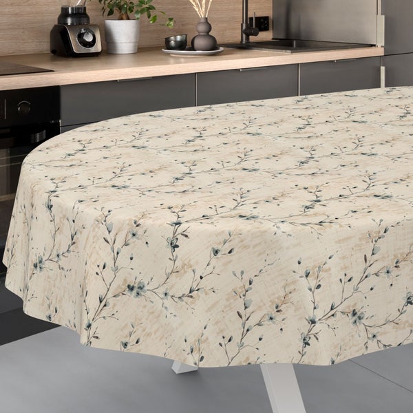 Runde Tischdecke mit filigranem Zweig- und Blumenmuster auf einem Esstisch in einer modernen Küche mit dunklen Fronten.