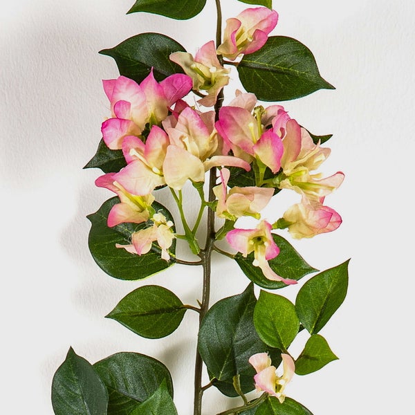 Künstlicher Bougainvillea-Zweig mit rosa und cremefarbenen Blüten sowie grünen Blättern.