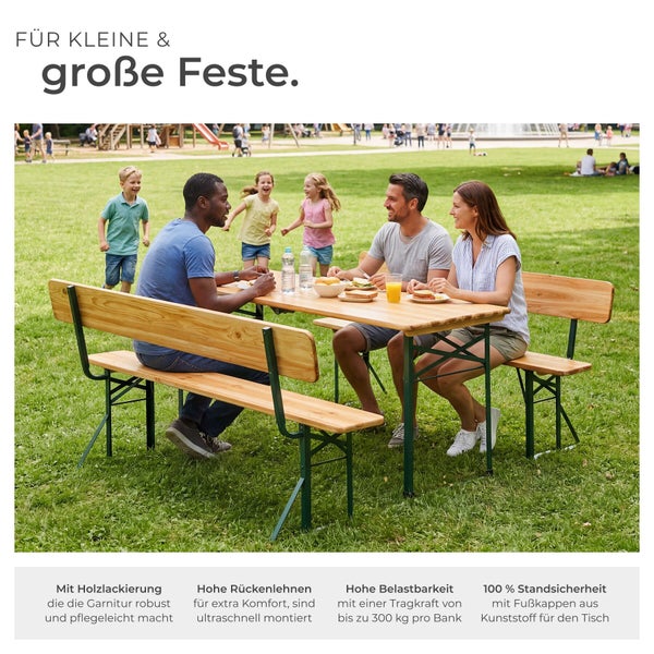 Bierzeltgarnitur aus Holz mit Rückenlehnen und grünem Metallgestell auf einer hellen Wiese mit Menschen beim Essen in einer organisierten Atmosphäre.