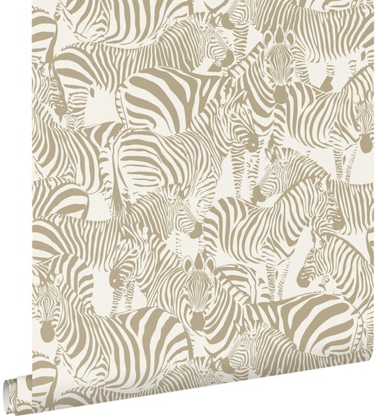 Selbstklebende Tapetenbordüre mit geometrischem Art-déco-Muster an einer Wand in einem modernen, hellen Wohnzimmer mit Sessel und Beistelltisch.