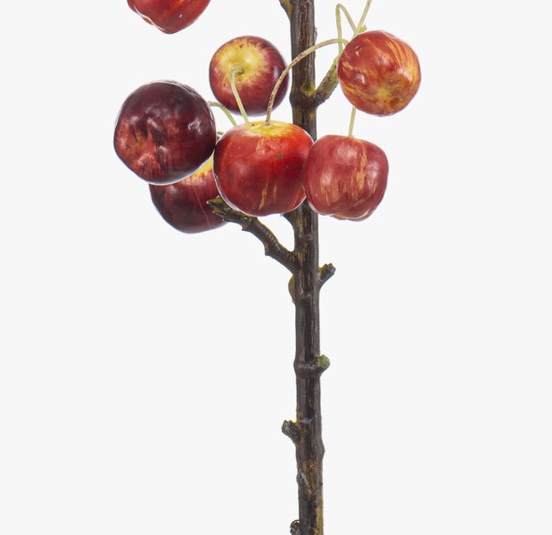 Künstlicher Zweig mit kleinen roten Äpfeln
