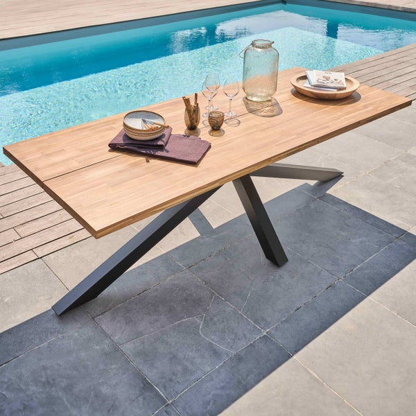 Moderner Gartentisch mit massiver Holzplatte und dunklem Metallgestell auf einer sonnigen Terrasse am Pool.