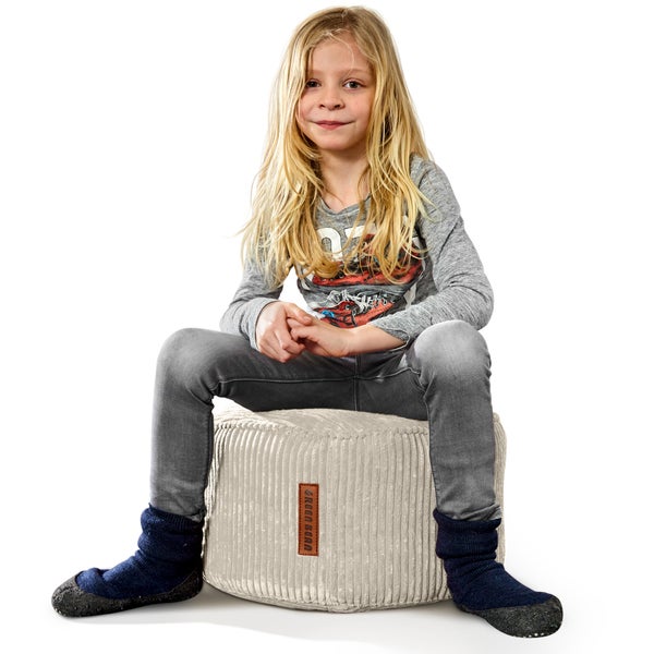 Kind sitzt auf einem Sitzhocker aus Cord mit Green Bean Logo
