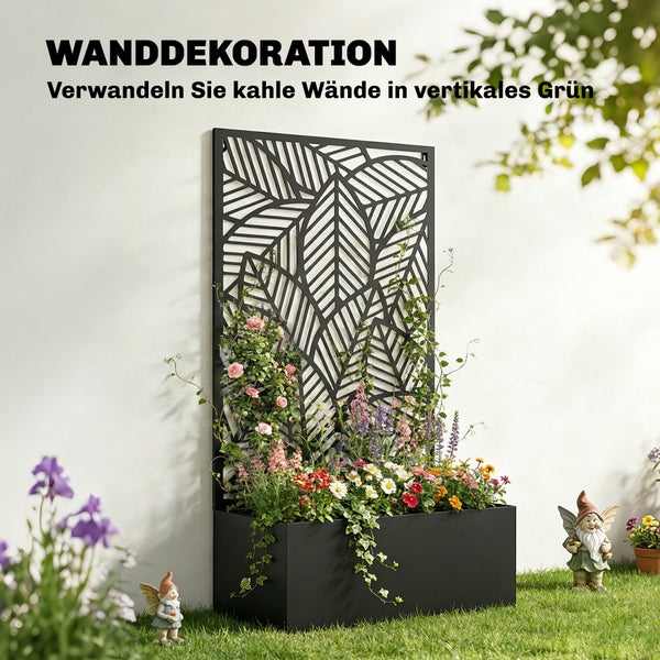 Schwarzer Wandpflanzkasten aus Metall mit blattförmigem Rankgitter, bepflanzt mit bunten Blumen auf einem Rasen vor einer Wand im Garten.
