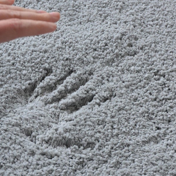 Grauer Teppich mit Handabdruck im Flor