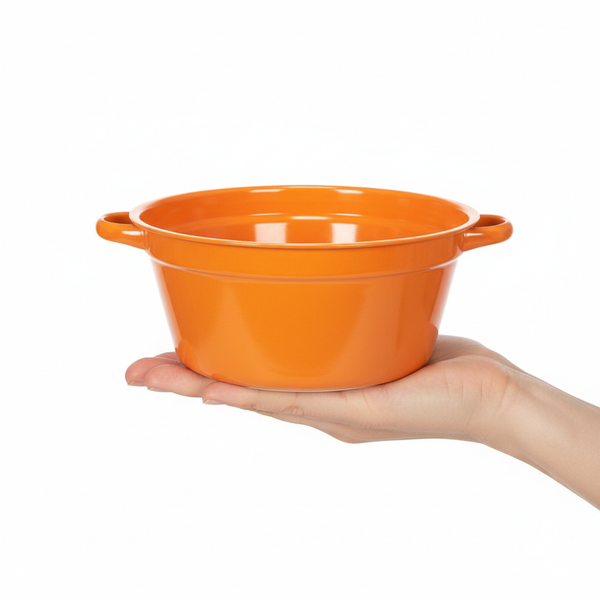 Kleine orangefarbene Keramikschale mit zwei Griffen, zur Veranschaulichung der Größe in einer Hand gehalten.