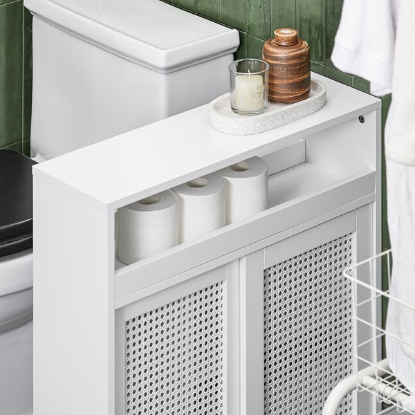 Weißer Badschrank neben einer Toilette mit Toilettenpapier und Dekorationen auf der Oberseite