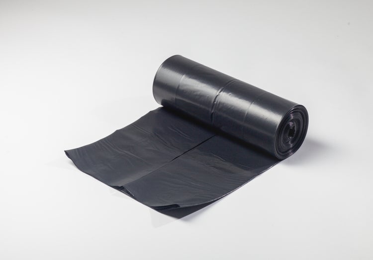 Hände halten eine schwarze Mülltüte