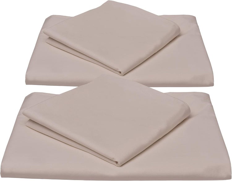 Zwei Sets beige Bettwäsche bestehend aus Laken und Kissenbezug aus glattem Textil.
