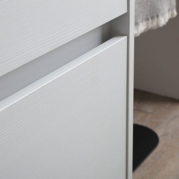 Nahaufnahme einer Badezimmerschrank-Schublade mit integrierter Griffleiste und Holzstruktur.