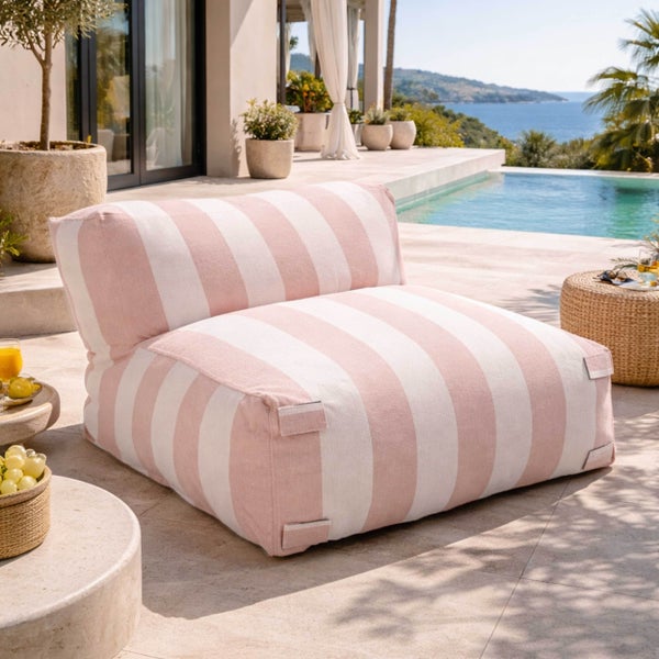 Gestreifter Outdoor-Loungesessel aus Stoff auf einer hellen Steinterrasse am Pool, moderne Gestaltung mit Meerblick, hell und weitläufig.