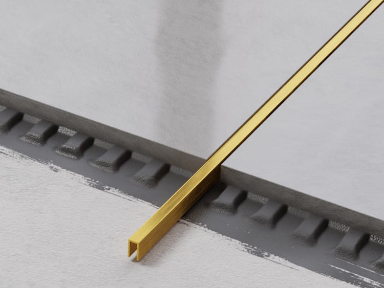 Goldfarbenes Fliesenschienenprofil für den Innenausbau.