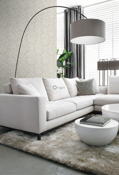 Wohnzimmer mit Ecksofa, Stehlampe, Couchtischen und Teppich