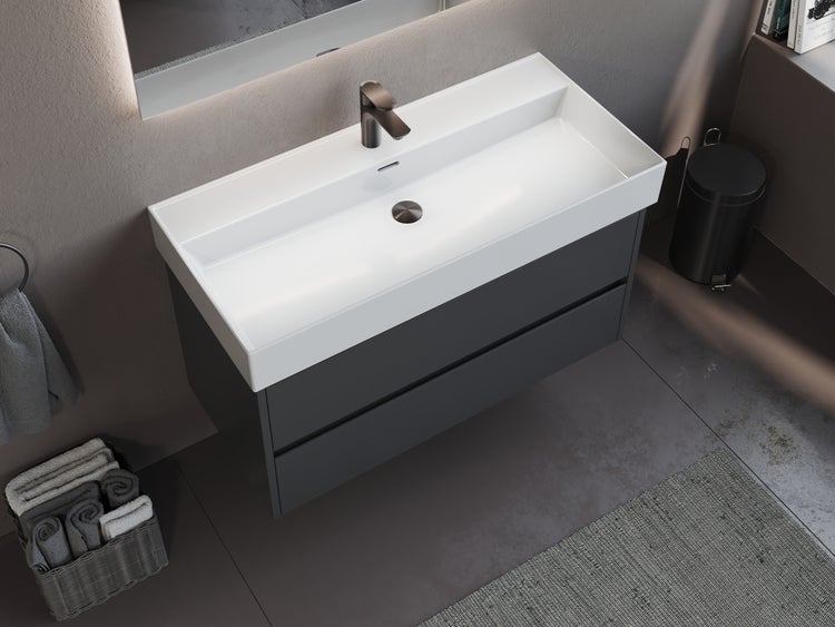 Wandhängender Waschtischunterschrank mit zwei Schubladen und breitem weißem Keramikwaschbecken in einem modernen Badezimmer.