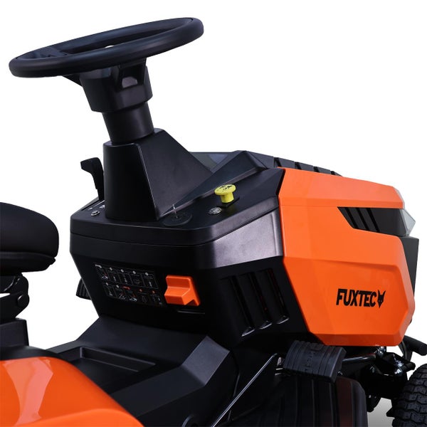 Detailansicht eines Aufsitzmähers mit Lenkrad und Bedienelementen sowie Fuxtec Logo.