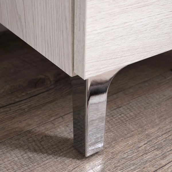 Verchromter Möbelfuß aus Metall an einem Schrank in heller Holzoptik.