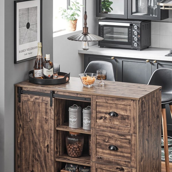Kücheninsel mit Schiebetür und Schubladen, dekoriert mit Getränken, Snacks und Vorratsbehältern für Zucker und Kaffee.