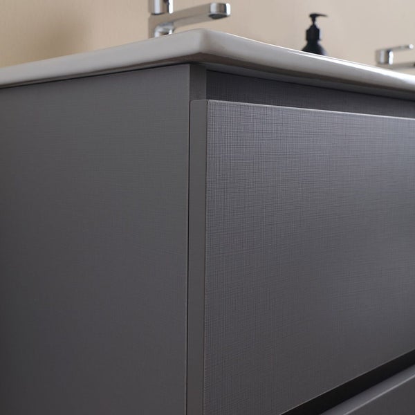 Detailansicht eines Waschtischunterschranks mit grauer Textur und weißem Waschbecken