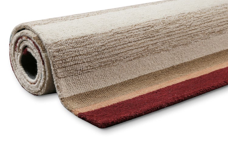Gerollter Teppich mit Streifenmuster in Creme, Beige und Rot mit weichem Flor.