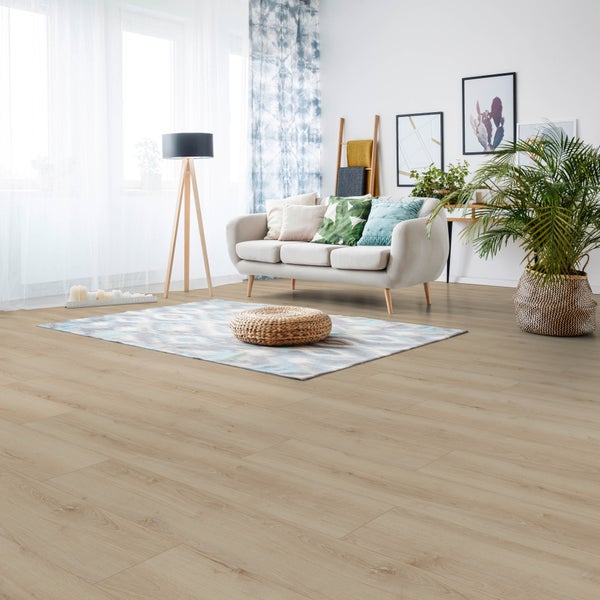 Helles Eichenlaminat verlegt in einem modern eingerichteten Wohnzimmer mit hellem Sofa und Zimmerpflanze.