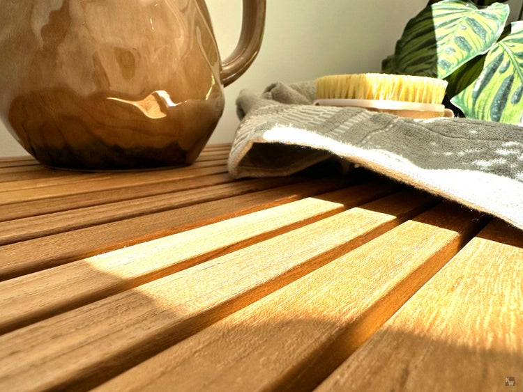 Dekorative Keramikkanne mit Handtuch und Bürste auf einem Holztisch