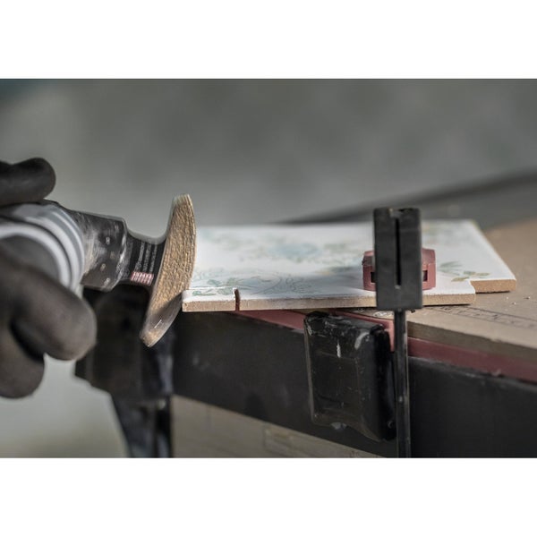 Eine Fliese wird mit einer oszillierenden Säge bearbeitet.