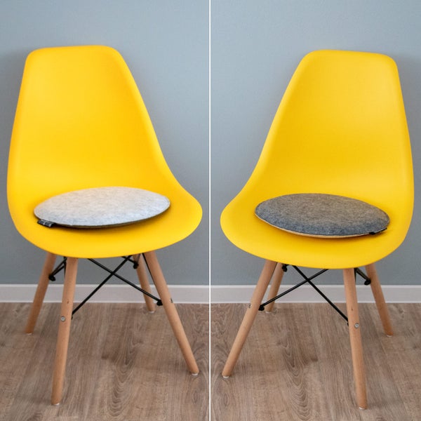 Gelber Schalenstuhl mit Holzbeinen und runden Sitzkissen aus Filz in Hellgrau und Dunkelgrau.