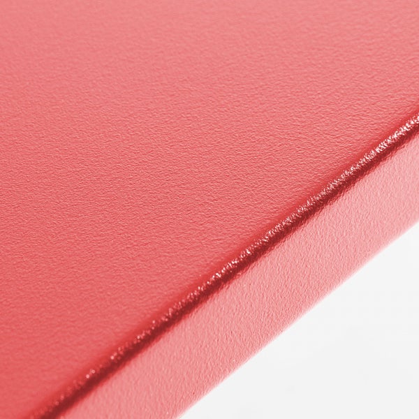 Nahaufnahme einer fein strukturierten roten Oberfläche mit einer abgerundeten Kante