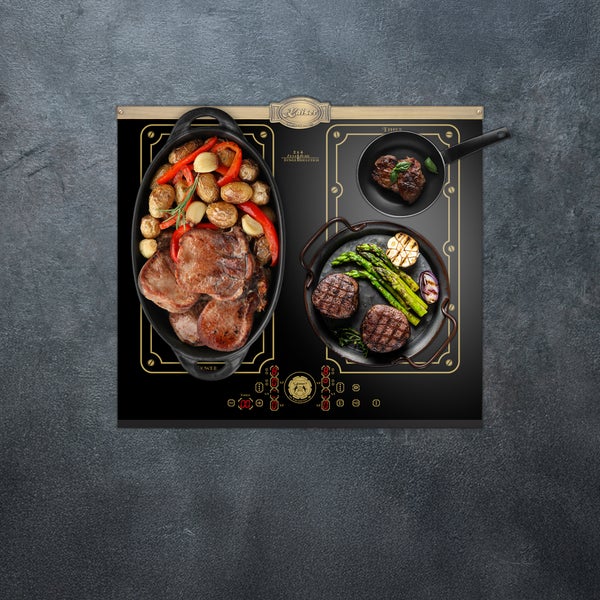 Kaiser Induktionskochfeld mit Bedienfeld und Töpfen mit gebratenem Fleisch und Gemüse.