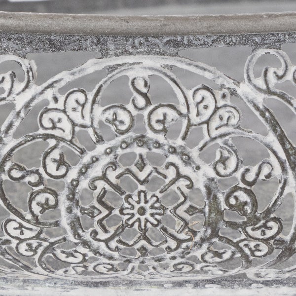 Detailansicht eines verzierten Metallmusters mit floralen Ornamenten im Vintage-Stil für Gartenmöbel.