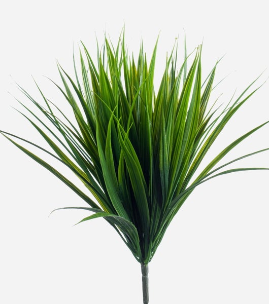 Detailaufnahme einer künstlichen Pflanze mit langen, schmalen grünen Blättern.